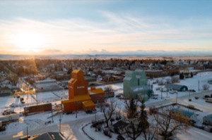 Aerial shot of nanton alberta with grain houses in foreground and town in the background on clear winter morning