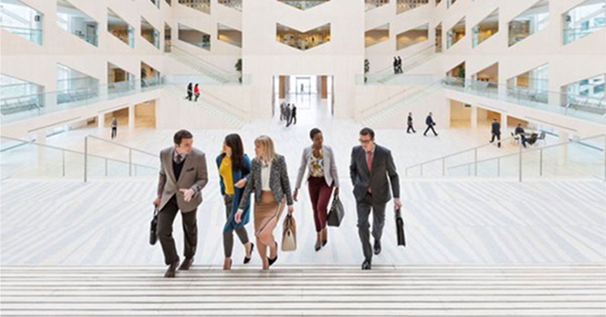 Buisness people walking up the stairs of city centre while talking to one another